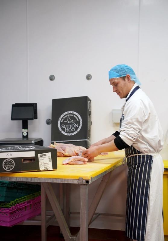 A Bodiam Foods butcher portioning poultry in the cutting room